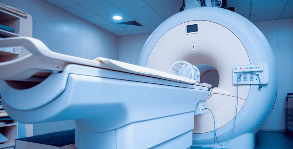 MRI scanner in a clinical room with the patient table extended, ready for imaging