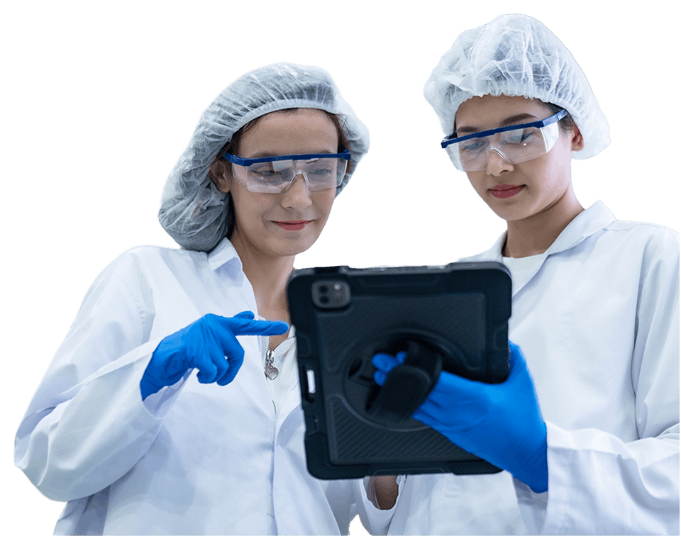 Two scientists in PPE examine a tablet together in the lab, wearing gloves and safety goggles.