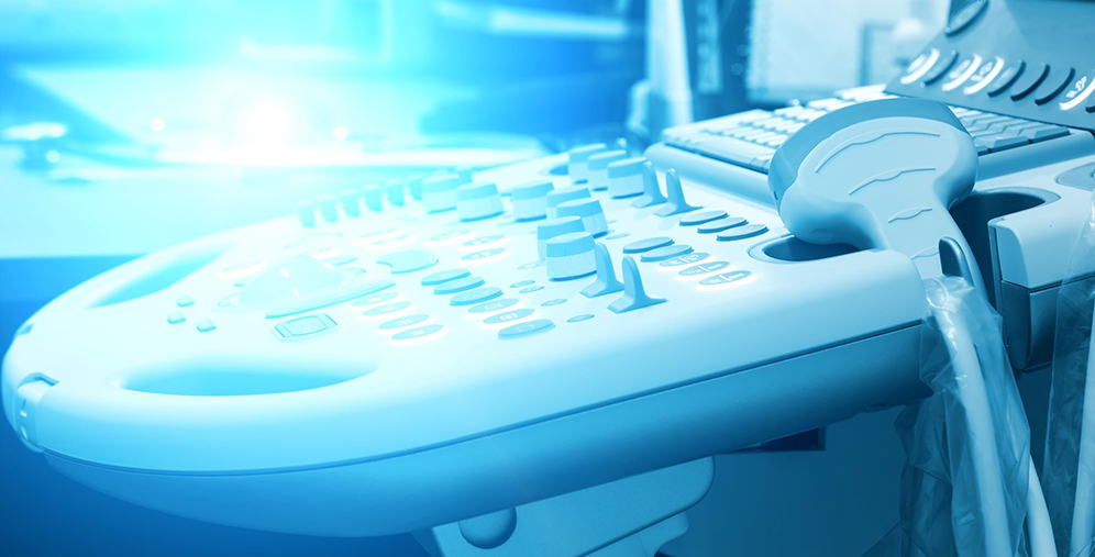 Close-up of a desk phone with a handset resting on the keypad, blue-tinted lighting.
